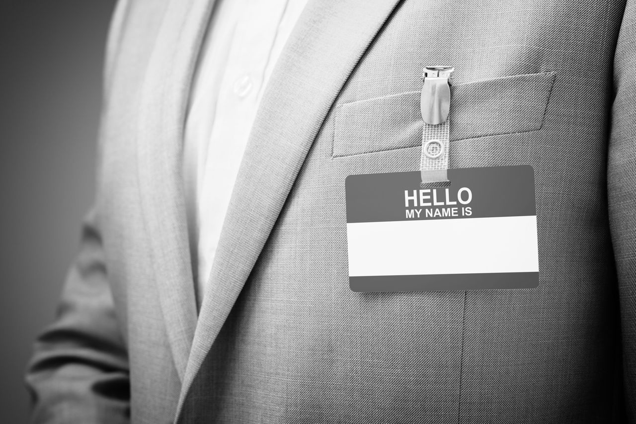 Businessman at an exhibition or conference wearing a Hello my name is security identity name card or tag